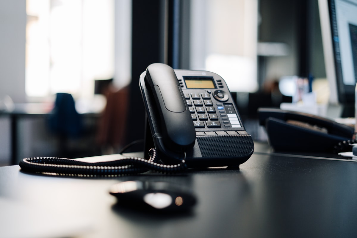 Business owner waiting for the phone to ring next to a laptop